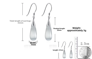 Detailed view of silver cat eye teardrop earrings with dimensions shown using a ruler