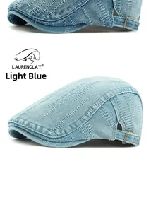 Detail of light blue denim flat cap showing washed texture and adjustable metal buckle