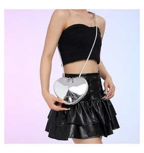 Detail der herzförmigen silbernen Metallic-Tasche mit Fashion-Schriftzug und Kette