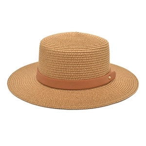 Close-up of straw boater hat texture with brown faux leather band and gold rivet detail