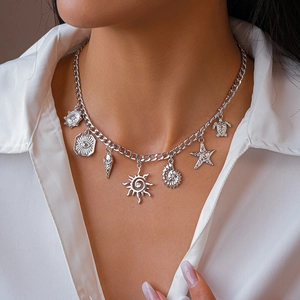 Macro detail of silver necklace with starfish shell sea turtle and sun charms on model