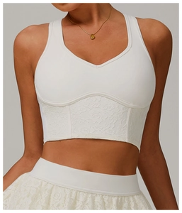 Detail of white V-neck crop top with delicate lace patchwork and structured seams