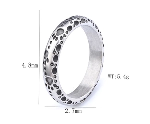 Detail view of silver stainless steel ring with crater texture and polished inner band