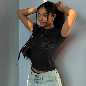Détail du t-shirt noir en dentelle ajusté pour femme avec motif floral et texture transparente