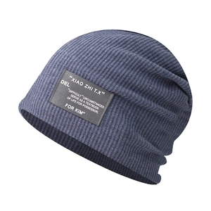 Detailed texture of dark blue knit beanie with a small logo patch and ribbed material