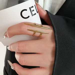 Macro detail of a polished gold double-layered ring with modern cone bar design