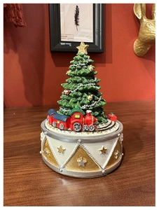 Detailed view of musical Christmas tree box with a red train on a star-patterned base