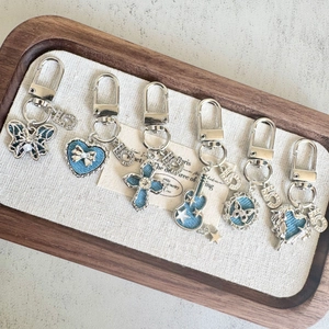 Retro denim alloy keychain set with butterfly, heart, cross, and guitar charms on a tray