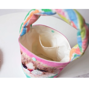 Detail of printed bucket bag with cat pattern, inner pocket and magnetic snap closure