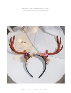 Detailed view of Christmas reindeer antler headband with silk flowers and berries