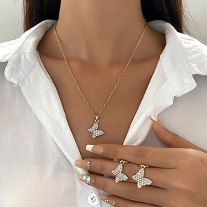 Detailed close-up of a golden butterfly necklace and earrings set with inlaid rhinestones