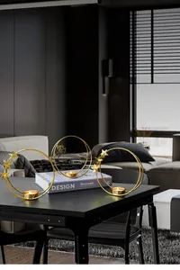Detail showing three gold iron candle holders with star and cupid motifs in modern home setting
