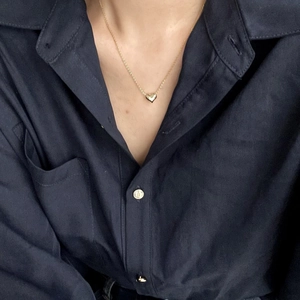 Minimalist 925 sterling silver heart pendant necklace in gold finish worn on a blue shirt