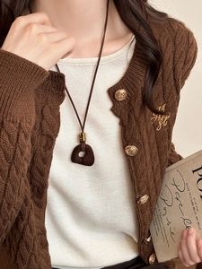Close-up of retro brown flocked resin pendant necklace on a knitted cardigan