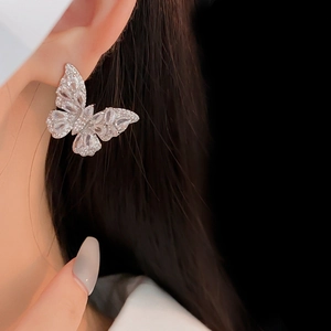 Macro shot of silver butterfly stud earrings with sparkling cubic zirconia on model