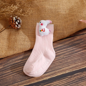 Close-up of pink baby sock with 3D white bunny doll and non-slip sole lettering