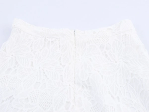 Detailed close-up of white floral lace texture and invisible zipper on the waist