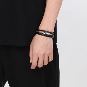 Macro detail of men's multilayer braided leather bracelet with silver magnetic buckle