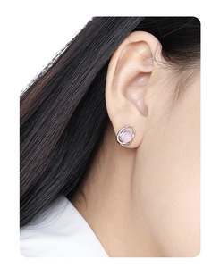 Primo piano dell'orecchino a lobo geometrico in argento S925 con opale rosa su modella