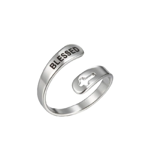 Détail de la bague en acier argenté avec croix et gravure BLESSED sur l'anneau ouvert