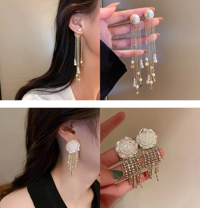 Detailed close-up of floral rose and pearl tassel earrings with shimmering crystals