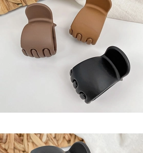 Close-up of matte plastic claw clips in dark brown, light brown, and black colors