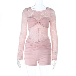 Detailed view of pink long sleeve lace romper with bow accent and ruffled hem