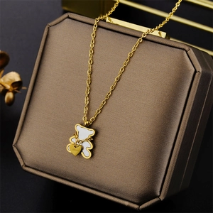 Titanium steel bear necklace with gold heart charm on a textured jewelry box