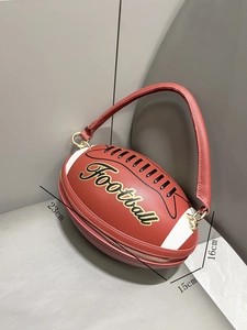 Detail view of a red football shaped handbag with size dimensions 23cm by 16cm and 15cm