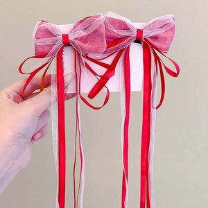 Close-up of red and white mesh bow hair clips with long ribbons for girls