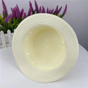 Detail view of the woven straw hat interior featuring a satin sweatband and spiral pattern