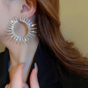 Macro shot of oversized silver hoop earrings with starburst crystal rhinestones