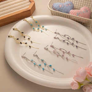 Detailed display of elegant leaf tassel earrings in various color combinations in a tray