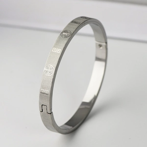 Close-up of matte silver titanium steel bracelet with geometric patterns and clasp