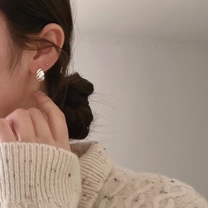 Elegant 925 sterling silver hoop earrings with twisted wave texture on female model