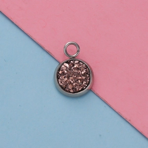 Macro shot of 12mm stainless steel starburst pendant with rose gold glitter texture inlay