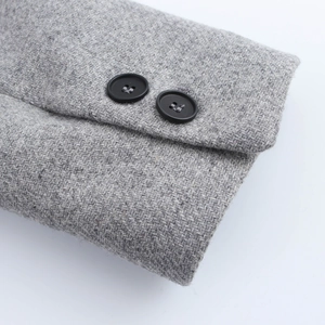 Macro view of grey herringbone wool fabric texture and black matte buttons on winter coat