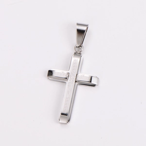 Close-up of polished silver stainless steel cross pendant with Greek key pattern