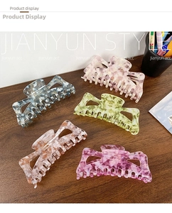 Detailed overhead shot of five colorful floral acetate hair claws in hollow triangle shapes