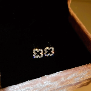 Close-up of sparkling hollow floral stud earrings with pavé crystals in a pink velvet box