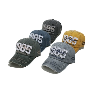 Multiple vintage washed baseball caps with 1985 embroidery and distressed brim details