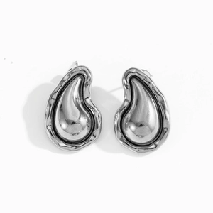 Macro view of silver irregular teardrop earrings with a polished lava texture