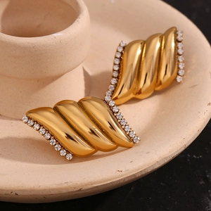 Dettaglio macro di orecchini ad ala d'angelo placcati in oro 18K con inserti in zircone