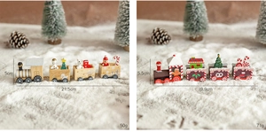 Detailed comparison of two wooden Christmas train models with miniature holiday figures