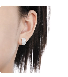 Close-up of S925 sterling silver stud earring with brushed texture and tiny zircon on ear
