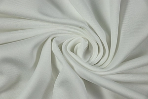 Close-up of white pleated knit fabric texture with elegant spiral draping detail
