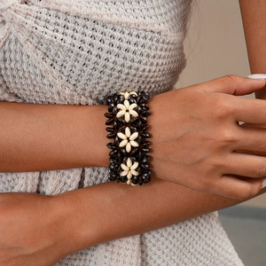 Detail of bohemian multilayer bracelet with coconut shell and wooden beads in floral pattern
