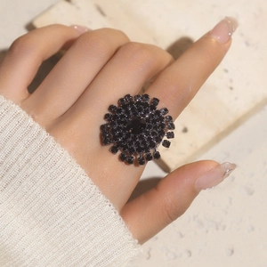 Close-up of a glamorous black crystal sunflower ring featuring a bold geometric rhinestone design