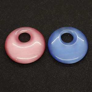 Detailed macro of smooth pink and blue cat eye stone pendants with side drilled holes