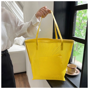 Macro detail of bright yellow mesh tote bag with durable PVC shoulder strap